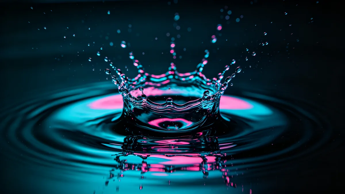 Un plano macro de una gota de agua que golpea una superficie quieta y forma una corona de salpicadura.