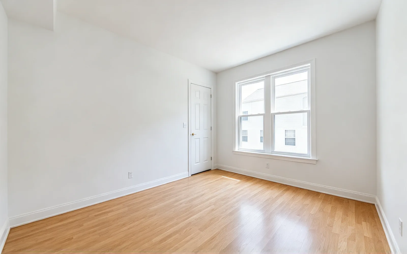 An empty bedroom staged in Scandinavian style with a bed, nightstands and a rug — Before