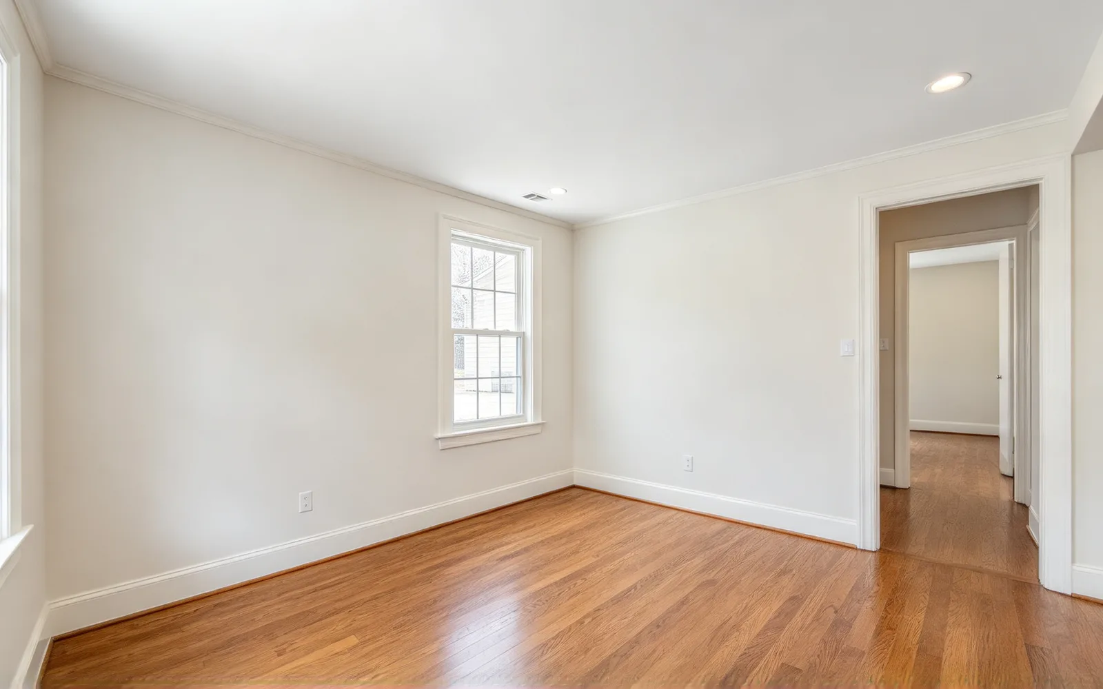 An empty dining room furnished in mid-century style with a table and chairs — Before
