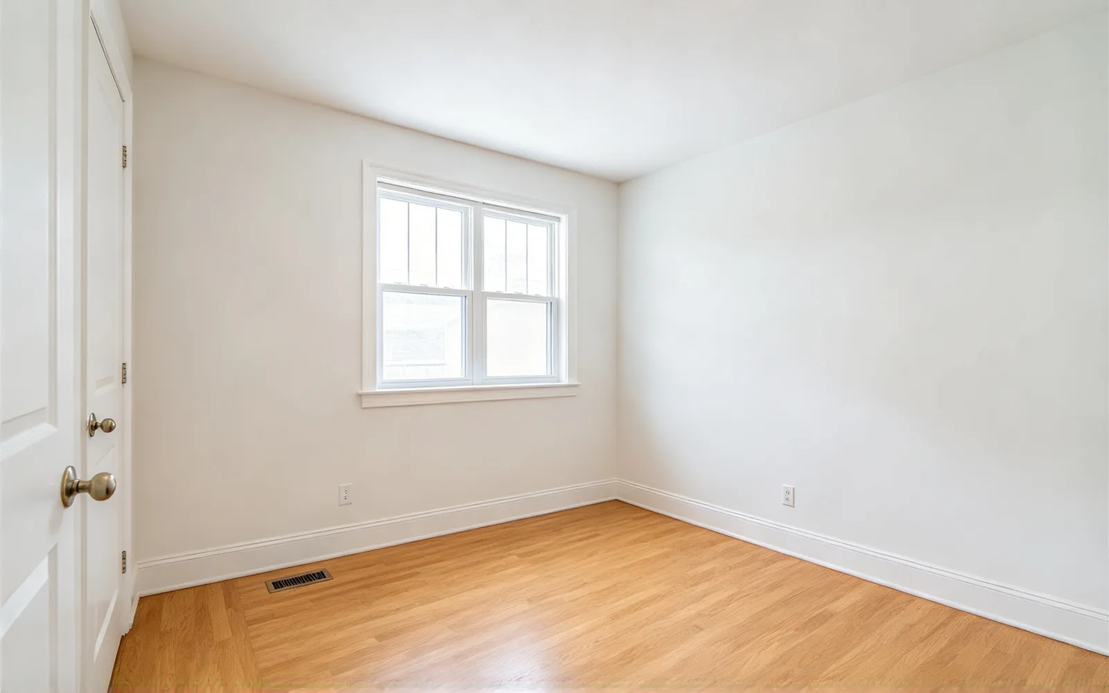 A bare spare room staged as a Japandi home office with a desk, chair and shelving — Before